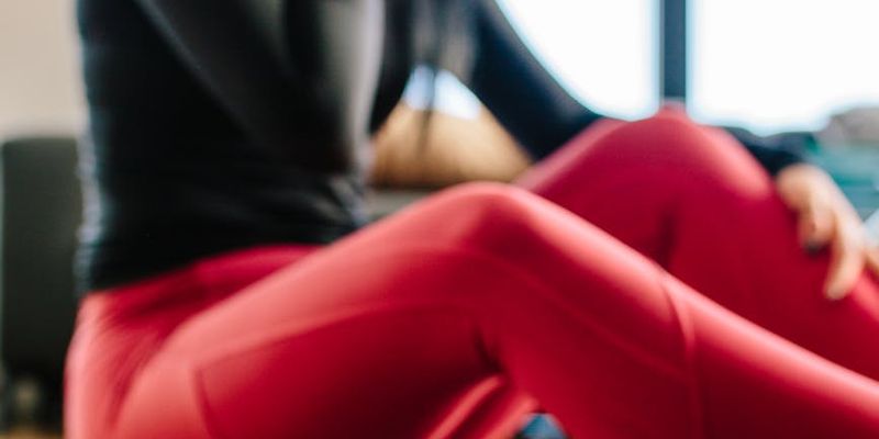 A rolled-up yoga mat and a water bottle on a wooden floor.