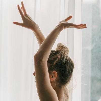 Silhouette of a person in a balancing yoga pose against a soft light.
